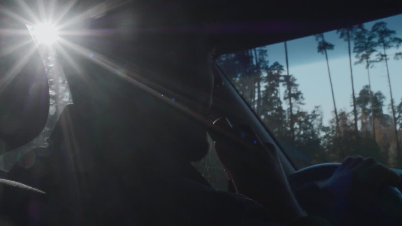 은 날 숲을 가로질러 차를 운전하는 남자