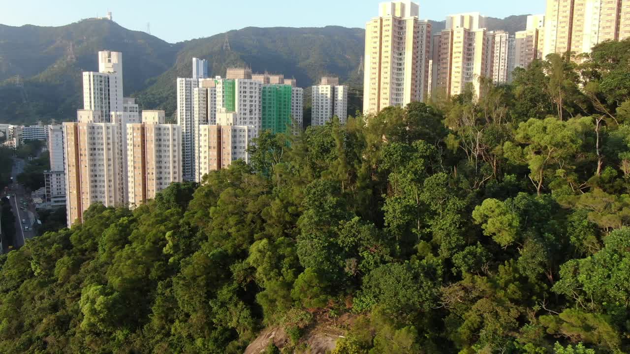 mega edificios residenciales en el centro de hong kong y lion rock mountain ridge en el fondo, vista aérea