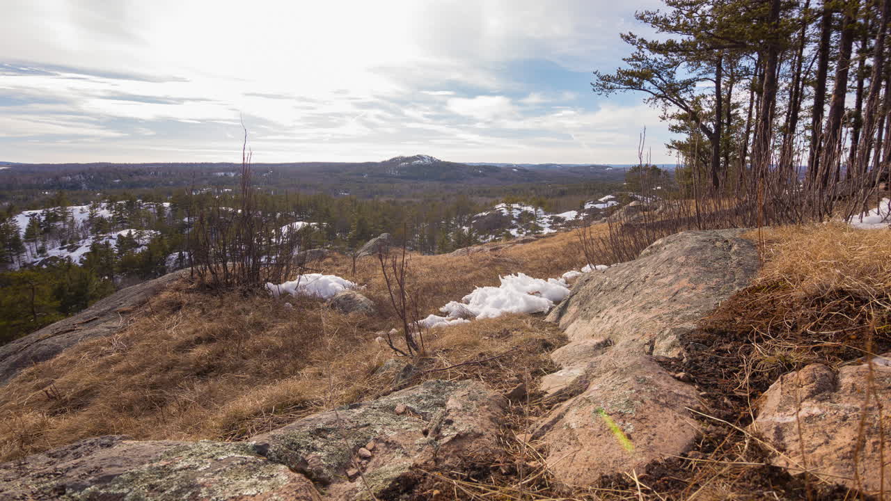 таймлапс движения облаков над лесистыми склонами холмов ранней весной или поздней зимой