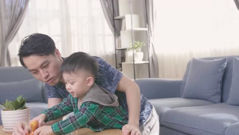 young asian man father playing toy with son at home
