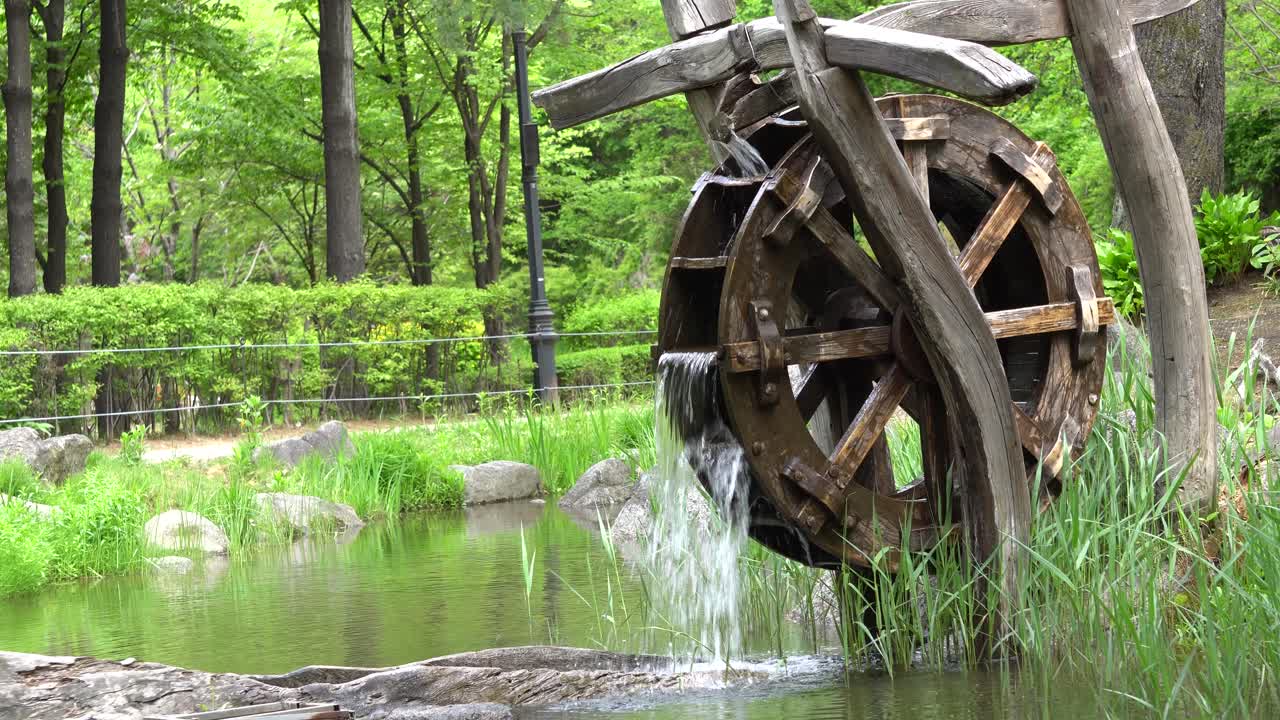 старое деревянное водяное колесо в парке намсан с зеленым лесом на горе намсан в сеуле, южная корея
