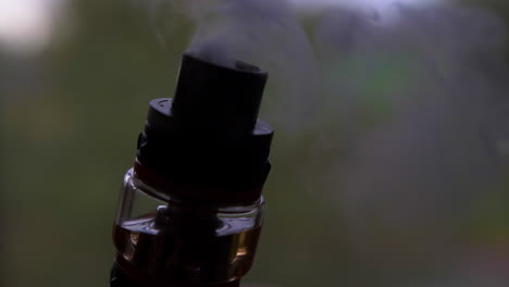 a close shot of the tank of a vaporizer while it smokes in slow motion