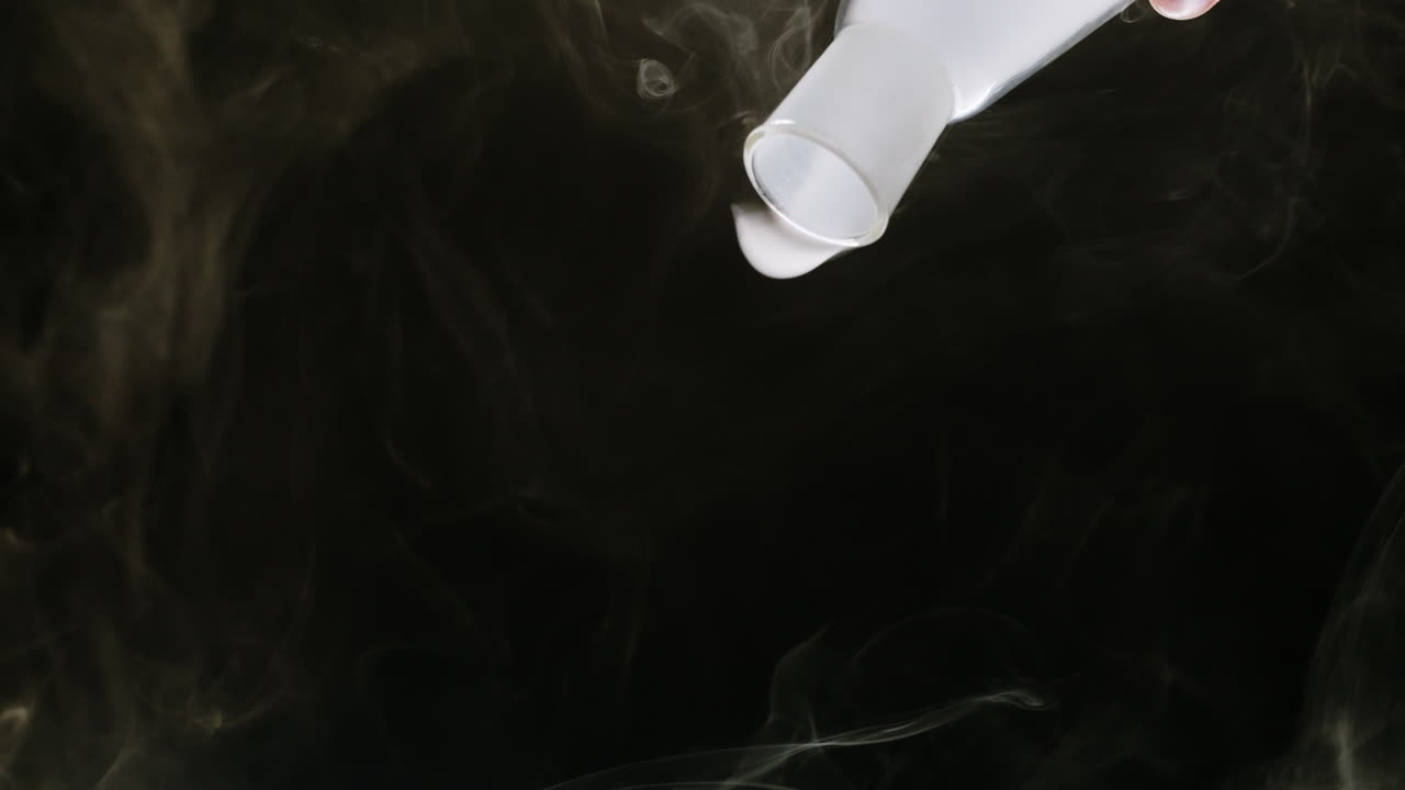 White Smoke Pouring from a Flask Against a Dark Background