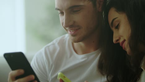 pareja feliz usando el teléfono móvil juntos en casa. pareja casada joven