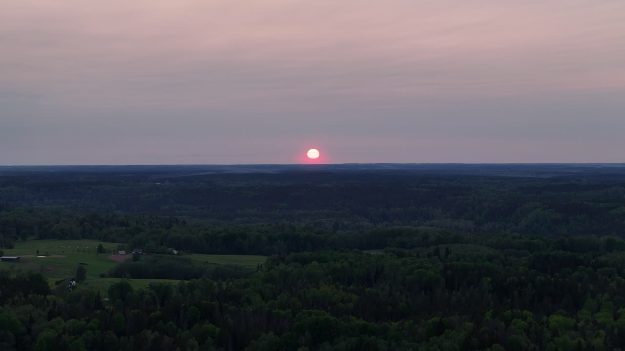 aerial shot moving away from a red glowing sunset in eastern europe