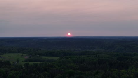 aerial shot moving away from a red glowing sunset in eastern europe