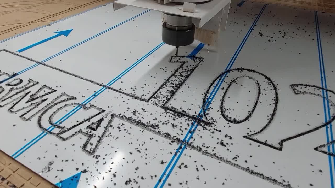 máquina enrutadora cnc cortando texto de placa de plástico