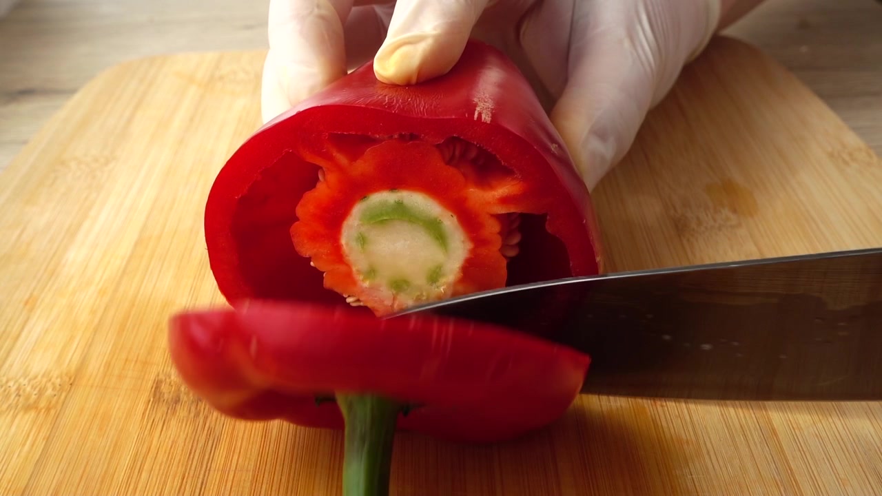 Kokken kutter rød paprika med en kniv. Sakte film
