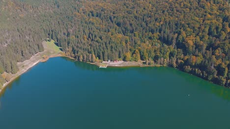 aerial view of saint anne lake, crater lake at ciomatu mare volcano with dense forest in romania