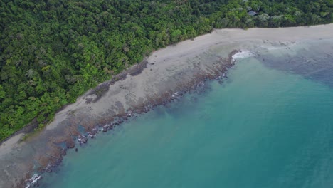 Waves-At-The-Beach-Splashing-On-The-Shore-Of-Cape-Tribulation-With-Dense-Rainforest-In-Tropical-North-Queensland,-Australia