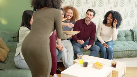 Multiethnic friends talking while a woman arriving with pizzas