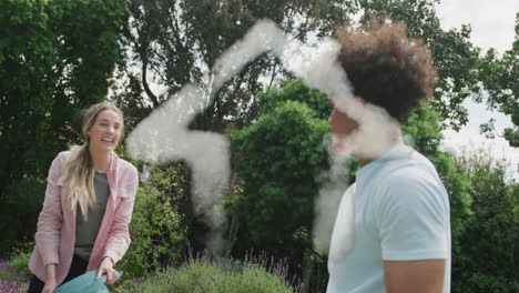 animación de la casa de las nubes sobre una pareja feliz y diversa teniendo una pelea de almohadas en el jardín