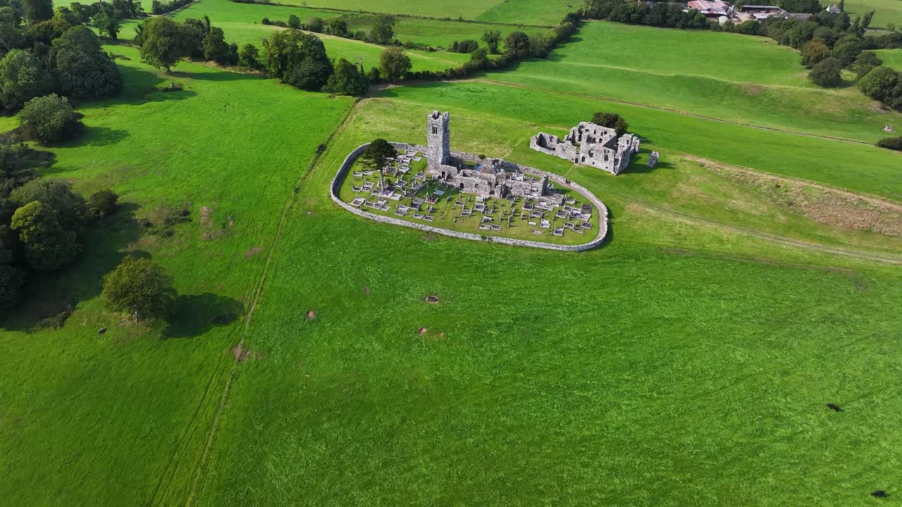 Aerial look down to Hill of Slane historic monastery with tower and college ruins. Ireland, countryside