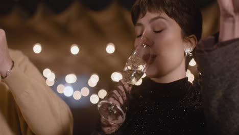 close up of happy friends toasting and drinking champagne at new year's eve party 1