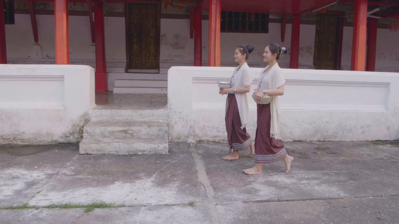 Two Girls In Thai Traditional Dress Walking Near Temple, Slow Motion