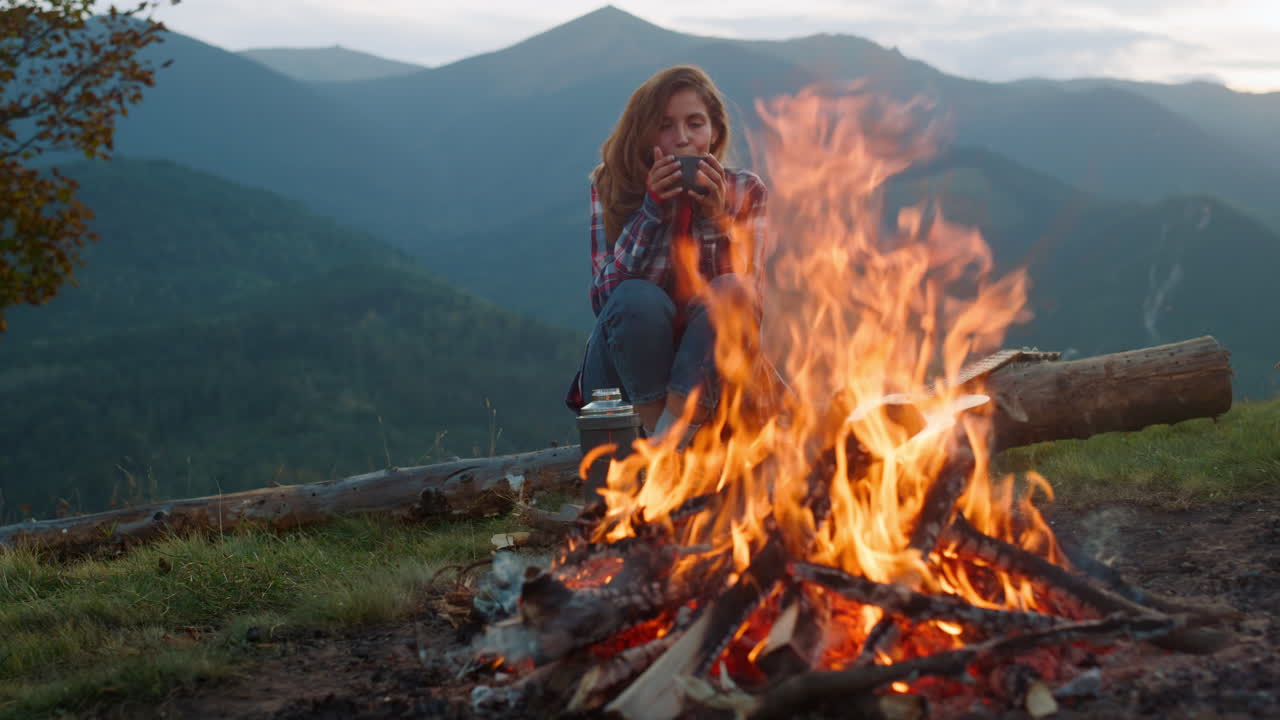 mujer relajada acampando en la naturaleza. aspecto turístico hoguera en el viaje a las montañas.