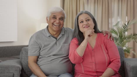 Happy-and-cheerful-Indian-old-couple-watching-TV