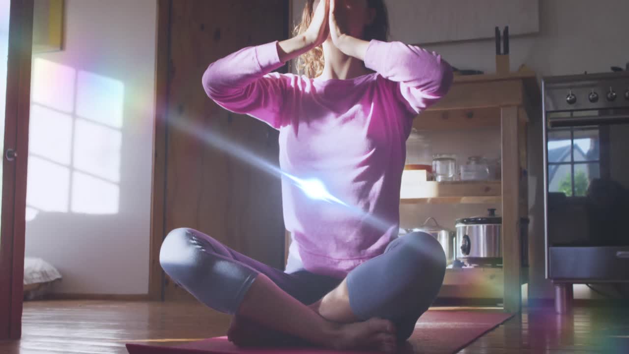 animación de puntos de luz sobre una mujer caucásica practicando yoga y meditando