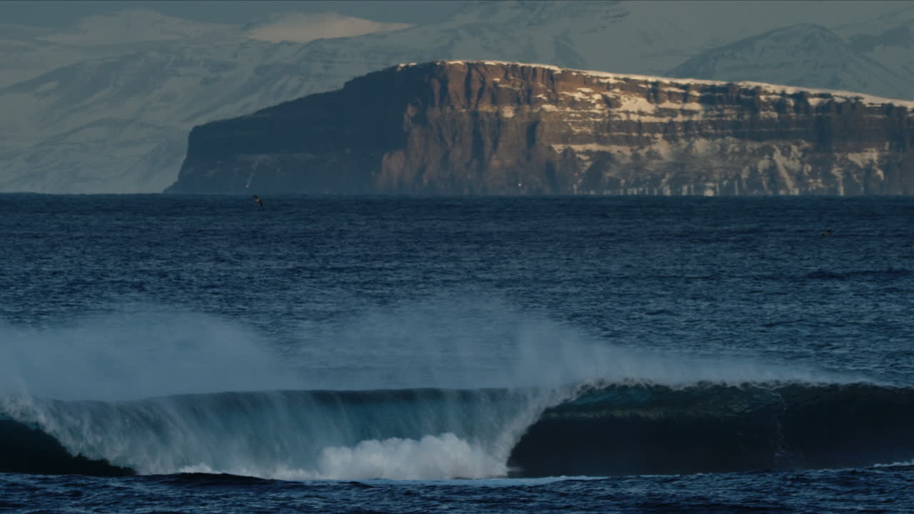 арктическая волна приземляется на мелководье в отдаленном исландии, снятая в замедленном режиме.