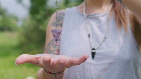 mujer haciendo movimiento de péndulo enfocándose con las manos al aire libre - cerrar