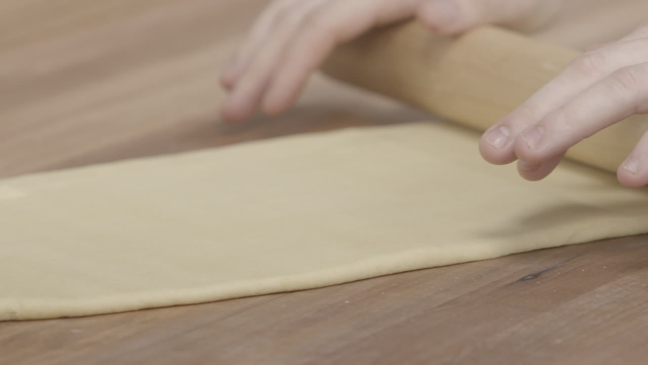 primer plano cámara lenta de un maestro chef rodando pasta a mano