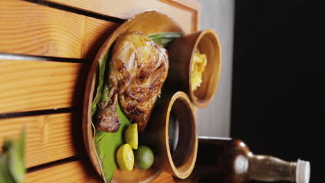 Portrait-Shot-of-Serving-Mouthwatering-Special-Chicken-Inasal-on-Traditional-Plate-with-Sauce-and-Salad,-Popular-Filipino-Grilled-Dish