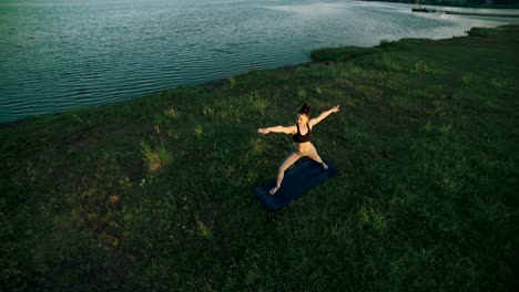 brunette woman practicing yoga in park. girl doing yoga moves on green grass