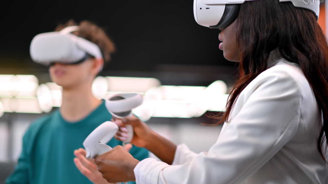 A black woman exploring virtual reality using VR glasses in an office, other people in VR glasses nearby