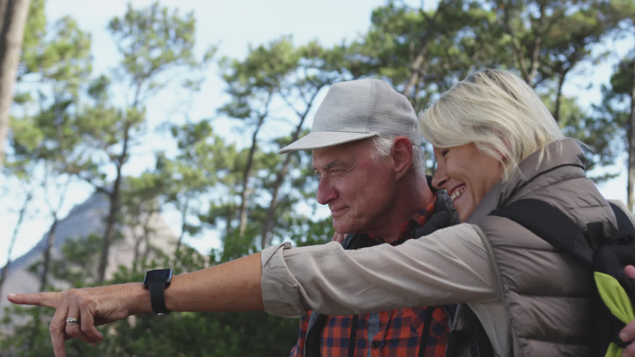 vista lateral de una pareja de ancianos activos en el bosque