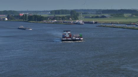 loaded cargo ships sailing through the river under grey sky due to air pollution and climate change, aerial view