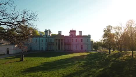 drone shot of a big mansion with sunflares coming