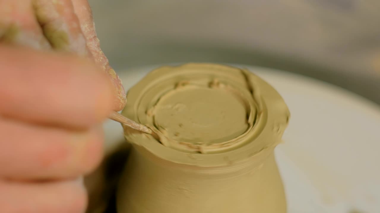 taza de tallado de alfarero profesional con herramienta especial en taller de cerámica