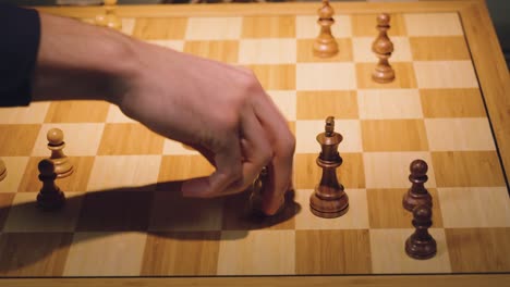 the hands of two chess players move the pieces alternately, taking some chess pieces off the chess board