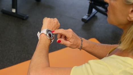 Ältere-Frau-überprüft-Ihre-Smartwatch-Im-Fitnessstudio-4k