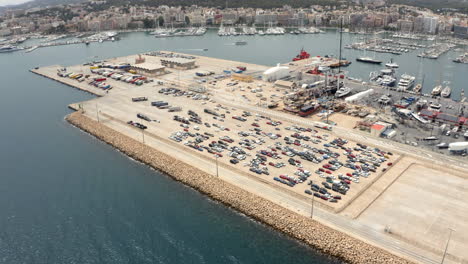 coches en un gran estacionamiento en la plataforma en el puerto de la ciudad de palma con barcos
