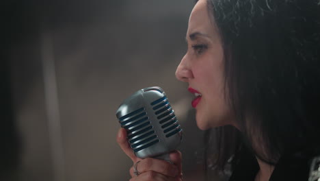 passionate female vocalist singing with deep emotion, holding a vintage microphone, set against a blurred background, highlighting her intense and heartfelt performance