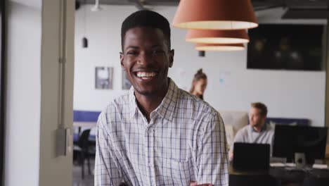 Retrato-De-Un-Feliz-Hombre-De-Negocios-Afroamericano-Mirando-La-Cámara-En-La-Oficina