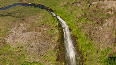 Aerial-view-orbit-around-Seljalandsfoss-waterfall-in-Iceland.-Drone-view-of-amazing-highlands-in-nordic-icelandic-countryside-with-water-falling-from-high-mossy-cliff