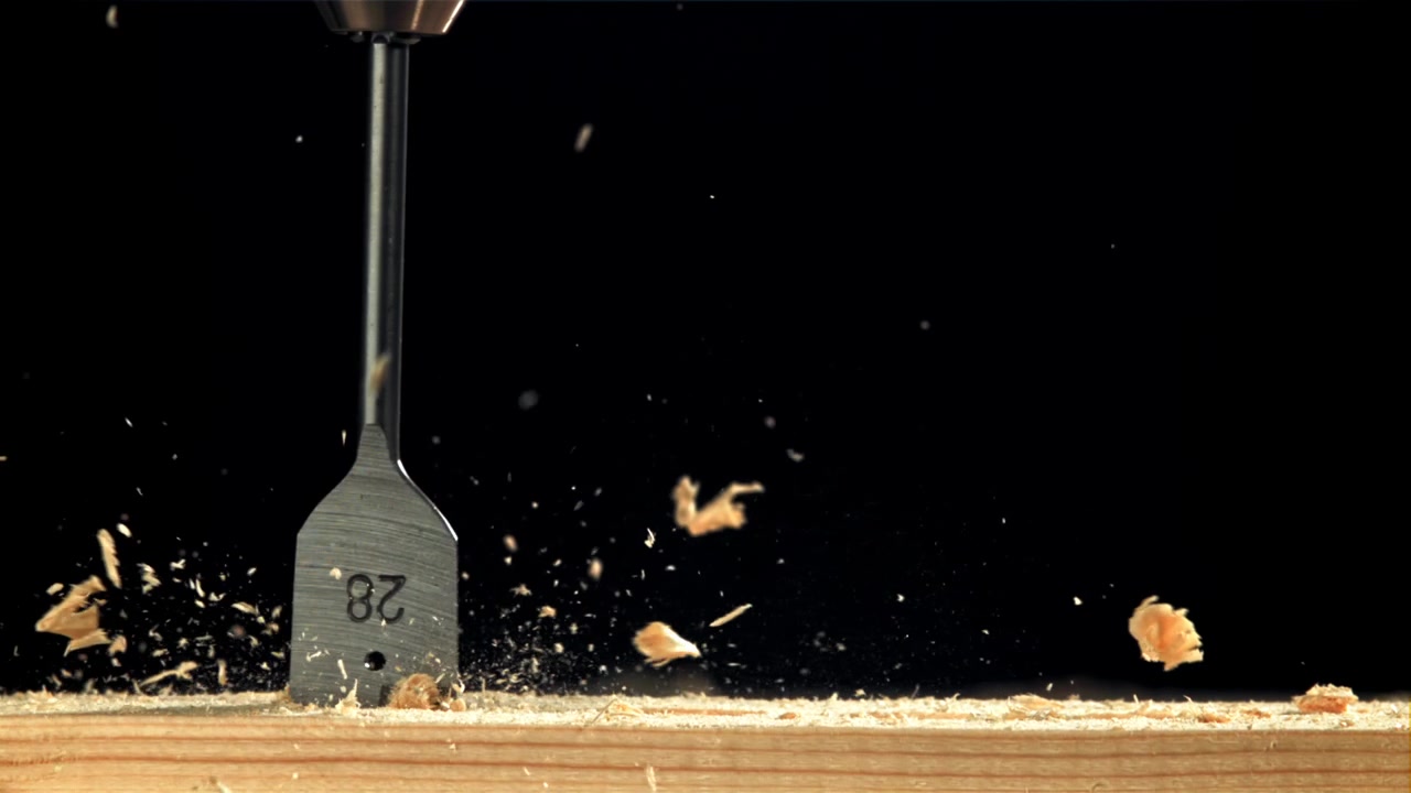 Close Up of a Spade Drill Bit Making a Hole in Wood in Slow Motion