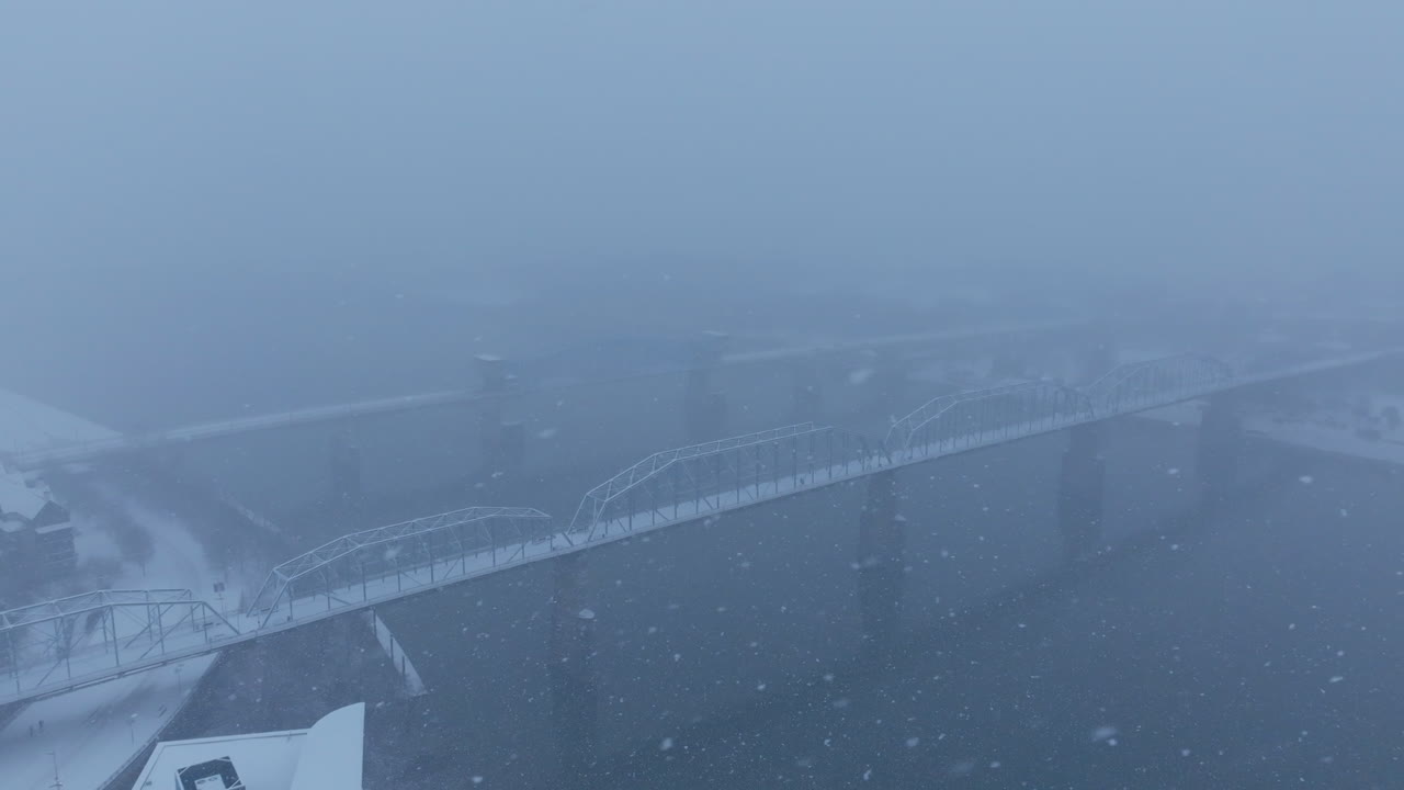 Aerial drone footage focused on the Walnut Street Bridge during a snowstorm in Chattanooga, TN.a
