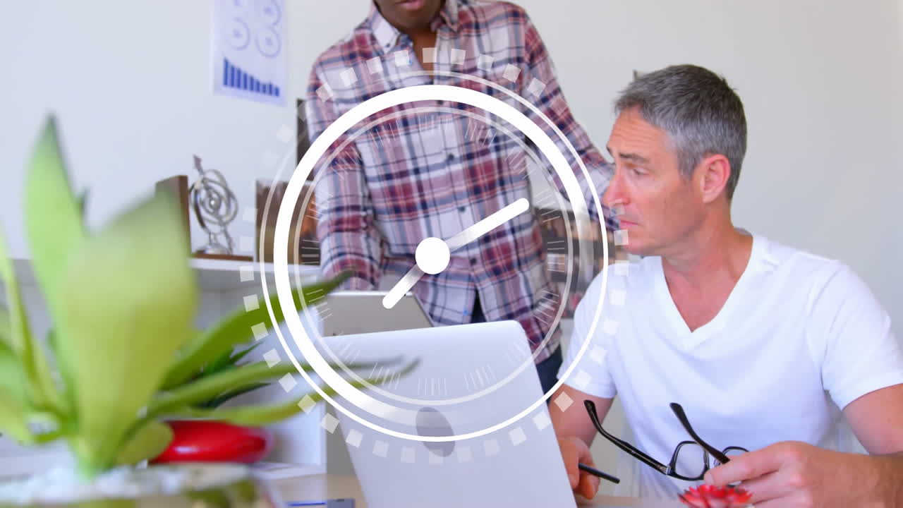 animación de reloj sobre dos hombres trabajando en una computadora portátil en la oficina