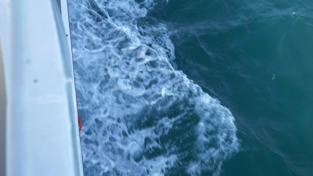 olas que emergen de debajo de un ferry que navega en el mar jónico