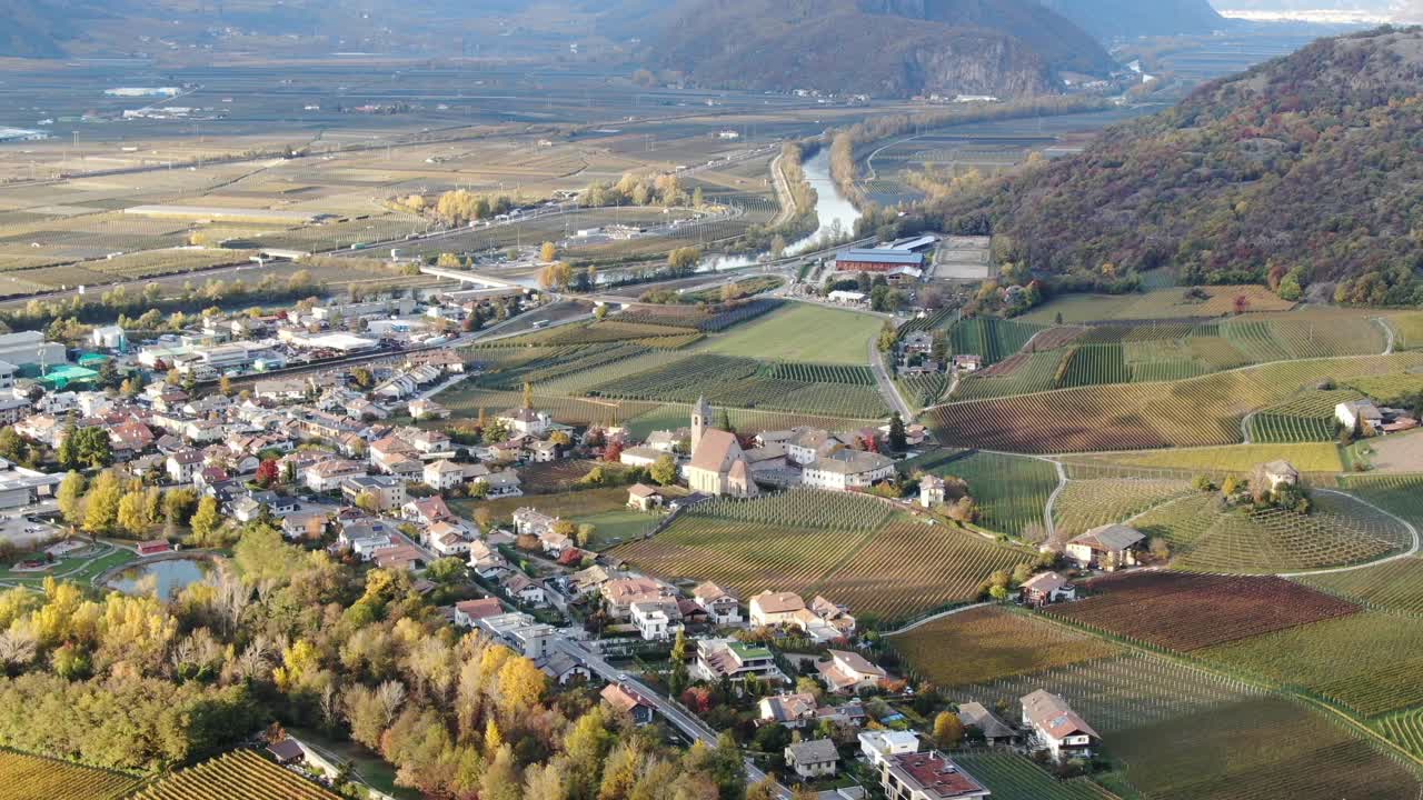 drone aéreo sobre los viñedos y un pequeño valle con una iglesia en el centro en otoño en tirol del sur