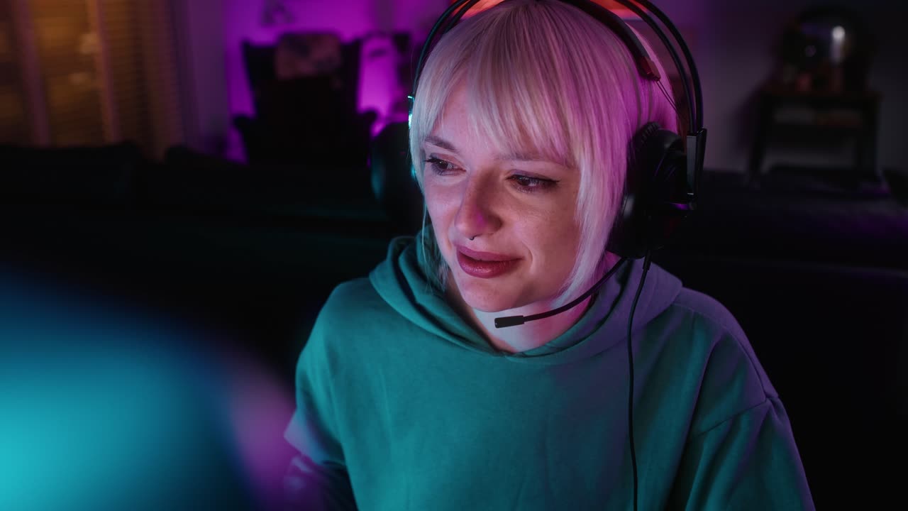 vista de alto ángulo de una joven mujer caucásica jugando al juego por la noche en la computadora de escritorio