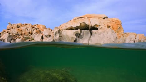 Halber-Unterwasserschwenkblick-Auf-Große-Granitfelsen-In-Der-Bucht-Cala-Della-Chiesa-Auf-Der-Berühmten-Französischen-Insel-Lavezzi-Zwischen-Korsika-Und-Sardinien,-Frankreich