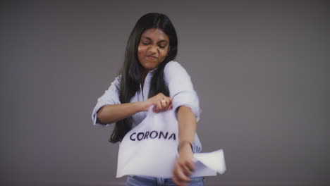 mujer joven rasga el retrato de signo de coronavirus