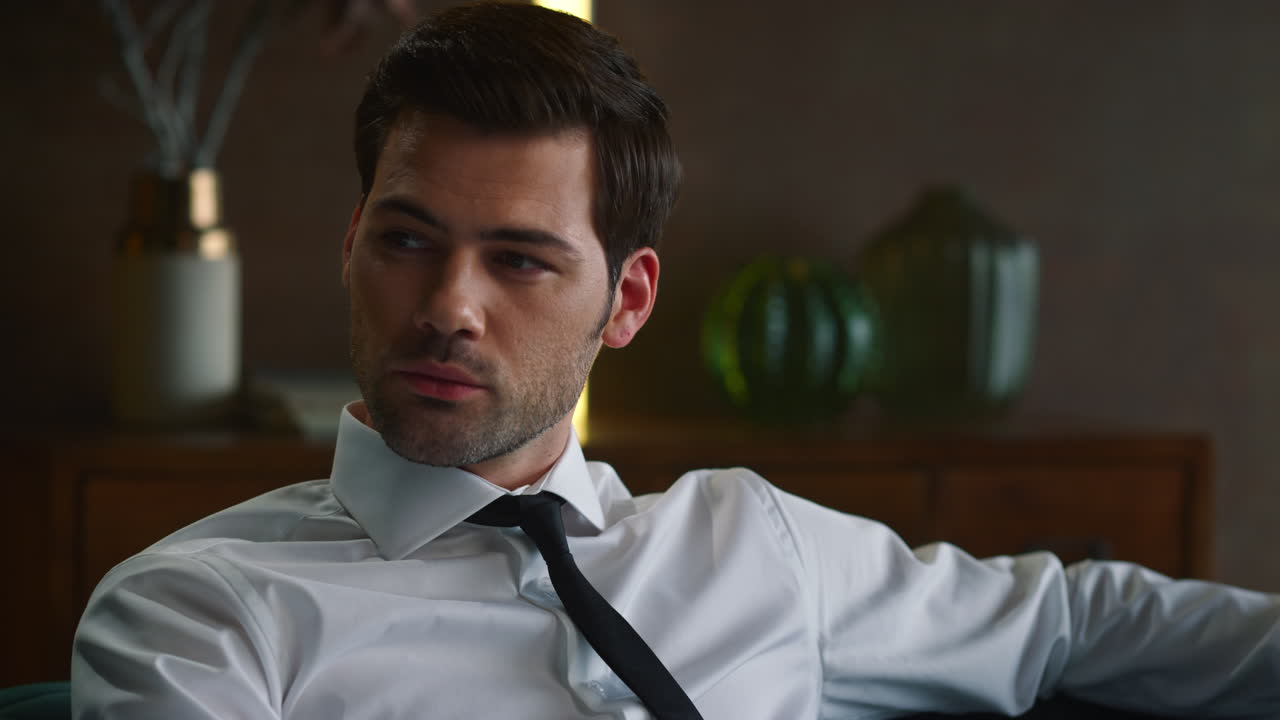 사무실 인테리어에서 소파에 앉아있는 사업가. 카메라를 보는 전문가