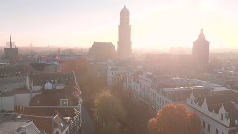 aerial view of the historic centre of the city of utrecht in the netherlands with the horizon drenched in sunlight showing the silhouetted church tower that rises high above the city