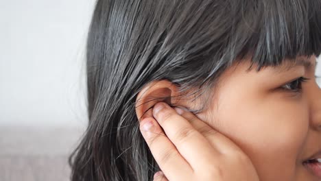 child having ear pain touching her painful ear ,,