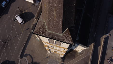 fast top down rise aerial shot of a church in the countryside of vionnaz, switzerland on a sunny day